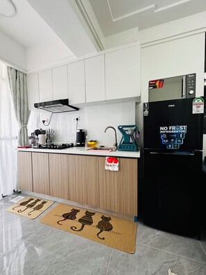 A modern kitchen with white cabinets, a black refrigerator, a coffee maker, and a kettle. - Cozy Modern Mini 2BR, Close to Yaya Centre & Top Cafes.
Gym,kids play pen, (Nairobi)