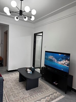 A modern living room with a flat-screen TV, a black coffee table, and a patterned rug. - Cozy Modern Mini 2BR, Close to Yaya Centre & Top Cafes.
Gym,kids play pen, (Nairobi)