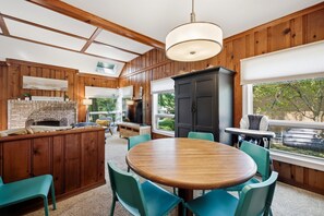 Een gezellige keuken met houten wanden, een centraal eiland en een eethoek met stoelen.