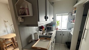 Eine kleine Küche mit Mikrowelle, Spüle und Arbeitsplatte aus Holz.