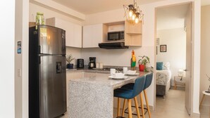 A modern kitchen with a stainless steel refrigerator, a microwave, and a granite countertop. - Escape to Cartagena and relax at Azul Sereno (Bolivar)