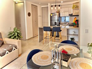 Een moderne keuken met een koelkast, barstoelen en een eettafel met placemats.