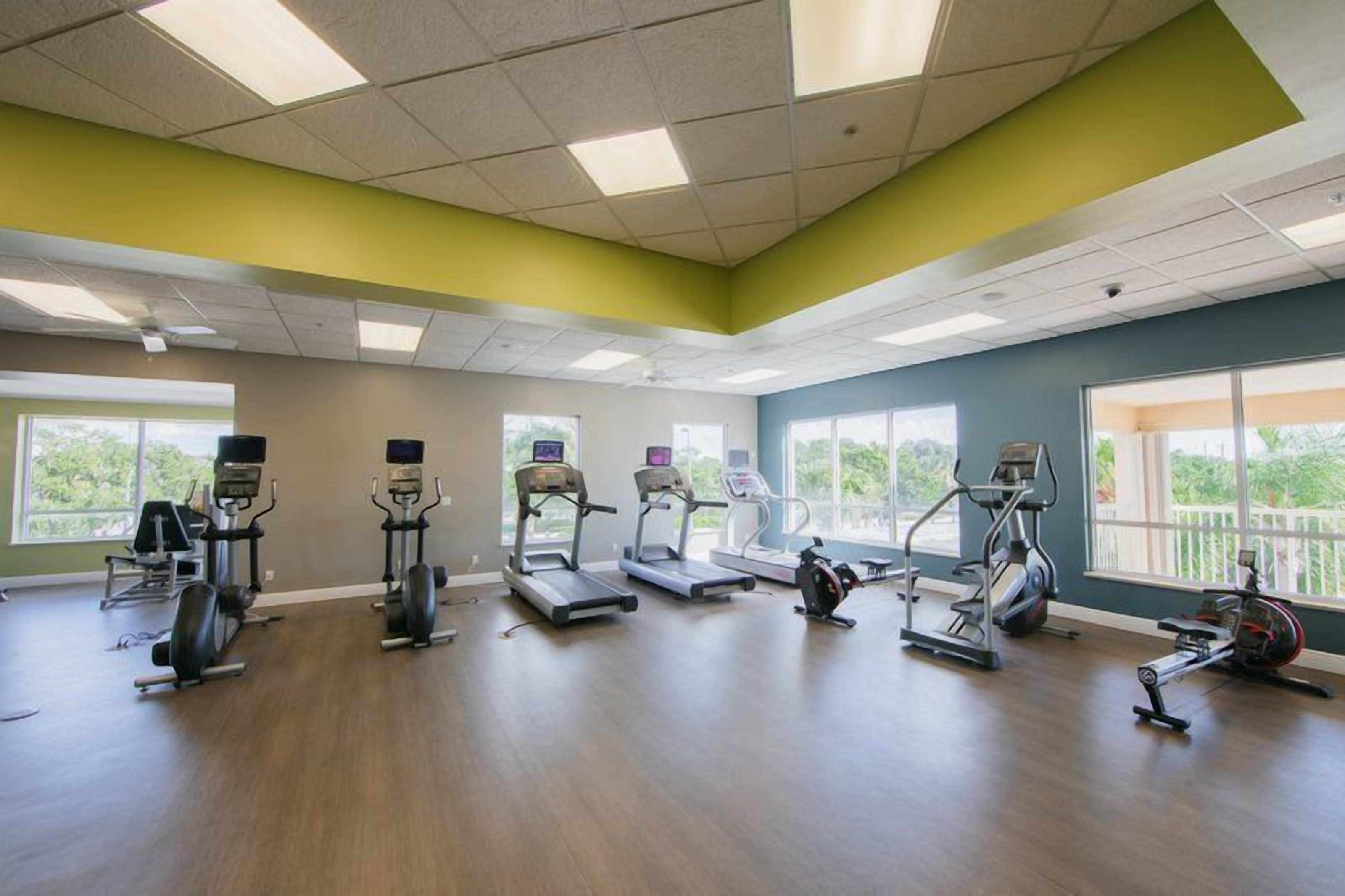 Ein Fitnessstudio mit Laufbändern, Crosstrainern und Rudergeräten.