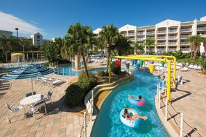 A pool area with lounge chairs, umbrellas, and a water slide. - Spacious 4BR Villa Near Beach & Access to Pools (Cape Canaveral)