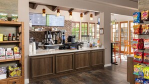 Una cafetería con mostrador, máquinas de café y una pizarra de menú.