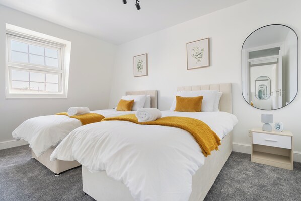A hotel room with two beds, a large mirror, and a window. - Luxe 4-bedroom house perfect for groups | great transport links! (London)