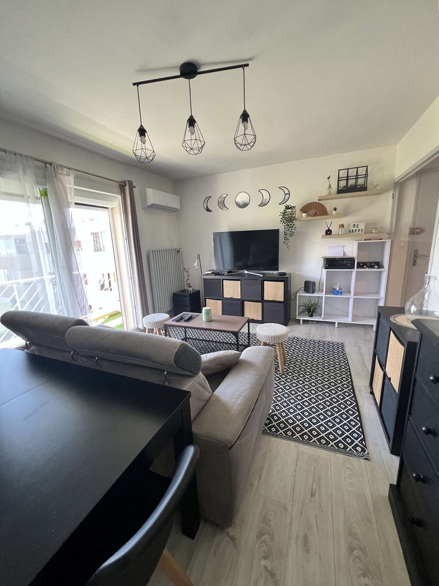 Un salon moderne avec un canapé, un téléviseur et un coin repas.