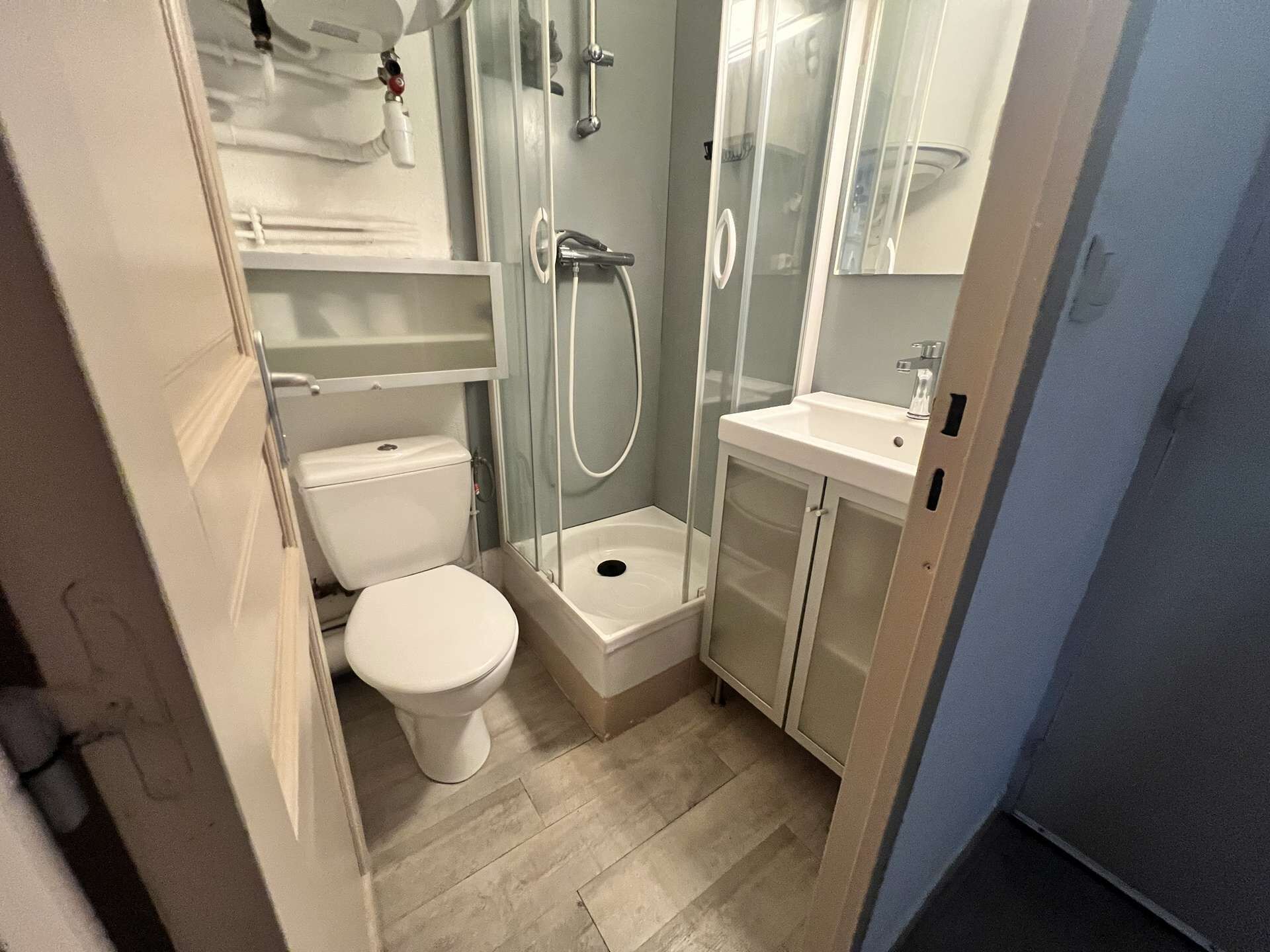 Ein kleines Badezimmer mit Toilette, Duschkabine und Waschbecken.