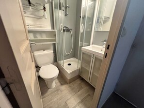 A compact bathroom with a toilet, a shower enclosure, and a sink. - Studio au calme à Beaucours – Plages à pied (SANARY SUR MER)