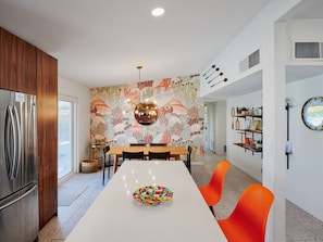 A modern kitchen with a white countertop, stainless steel refrigerator, and a colorful wall mural. - Desert Dream - Pool Heat Avail. - Mins to Old Town (Scottsdale)