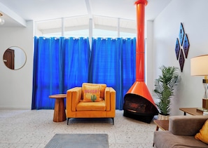 A living room with a fireplace, blue curtains, and a cactus pillow. - Desert Dream - Pool Heat Avail. - Mins to Old Town (Scottsdale)
