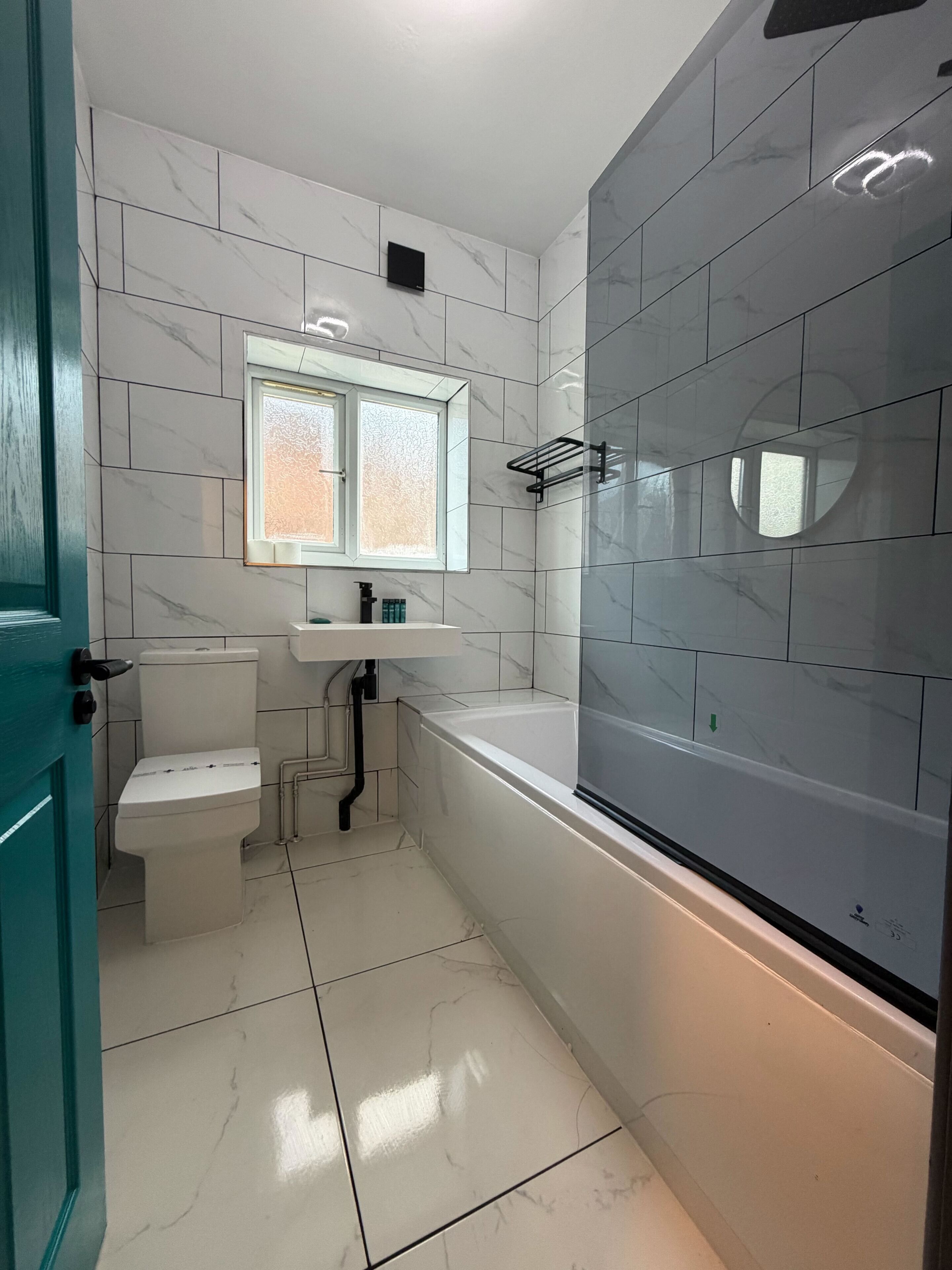 A modern bathroom with a toilet, sink, and bathtub.