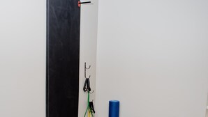 A small, private room with a black exercise wall, a blue exercise ball, and a yoga mat. - Accessible 1BR Suite w/ Free Hot Breakfast + Pool (Humble)