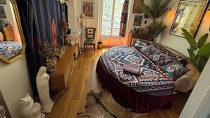 A bedroom with a large bed, a window, a mirror, and various decorations. - Retro and Rock 'n' Roll Room in Bastille! (Paris)