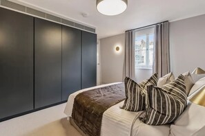 Ein Schlafzimmer mit Bett, Fenster und Kleiderschrank.