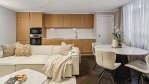 Una cocina moderna con armarios de madera, horno integrado y encimera blanca.