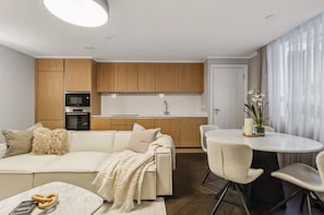 A modern kitchen with wooden cabinets, a built-in oven, and a white countertop. - 7 Mins Walk to Selfridges Luxury Marble Arch Apt (London)
