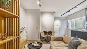 A modern living room with a sofa, a coffee table, and a dining area with chairs. - 9 Mins Walk to Selfridges Marble Arch Studio (London)