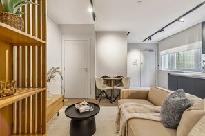 Ein stilvolles Wohnzimmer mit einer Couch, einem Couchtisch und einem Essbereich mit Stühlen.