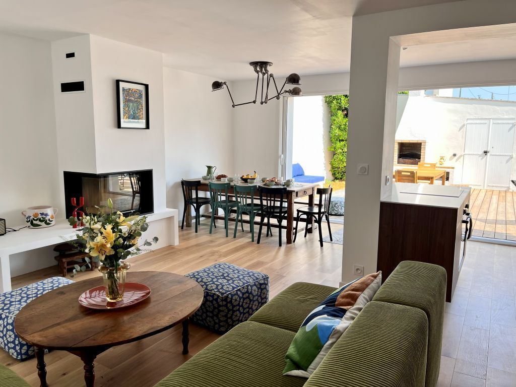 Un soggiorno moderno con un divano, un'area pranzo con sedie, una televisione e un caminetto.