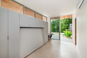 A modern kitchen with sliding doors leading to a garden. - Hilltop Villa: Infinity Pool & Ocean Horizon (Playa Grande)