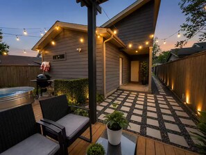A backyard with a patio, outdoor seating, a barbecue grill, and string lights. - Central Houston Bungalow Cowboy Pool & EV Charger (Houston)
