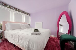 Een slaapkamer met een bed, een spiegel en een stoel.