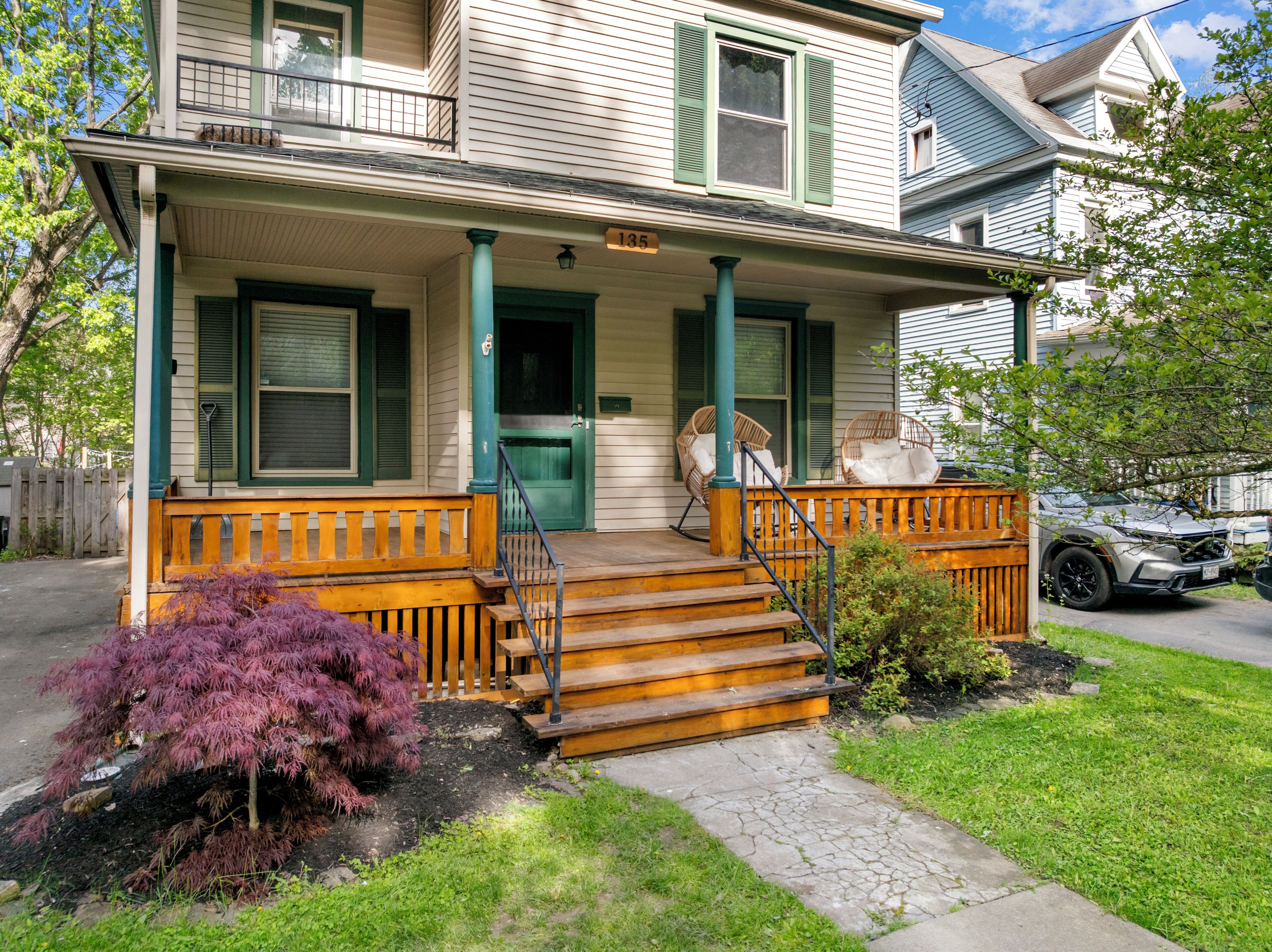 A two-story house with a porch, a front door, and a mailbox.