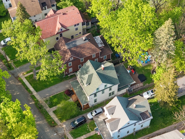 Vista aérea de una zona residencial con casas, árboles y coches aparcados.
