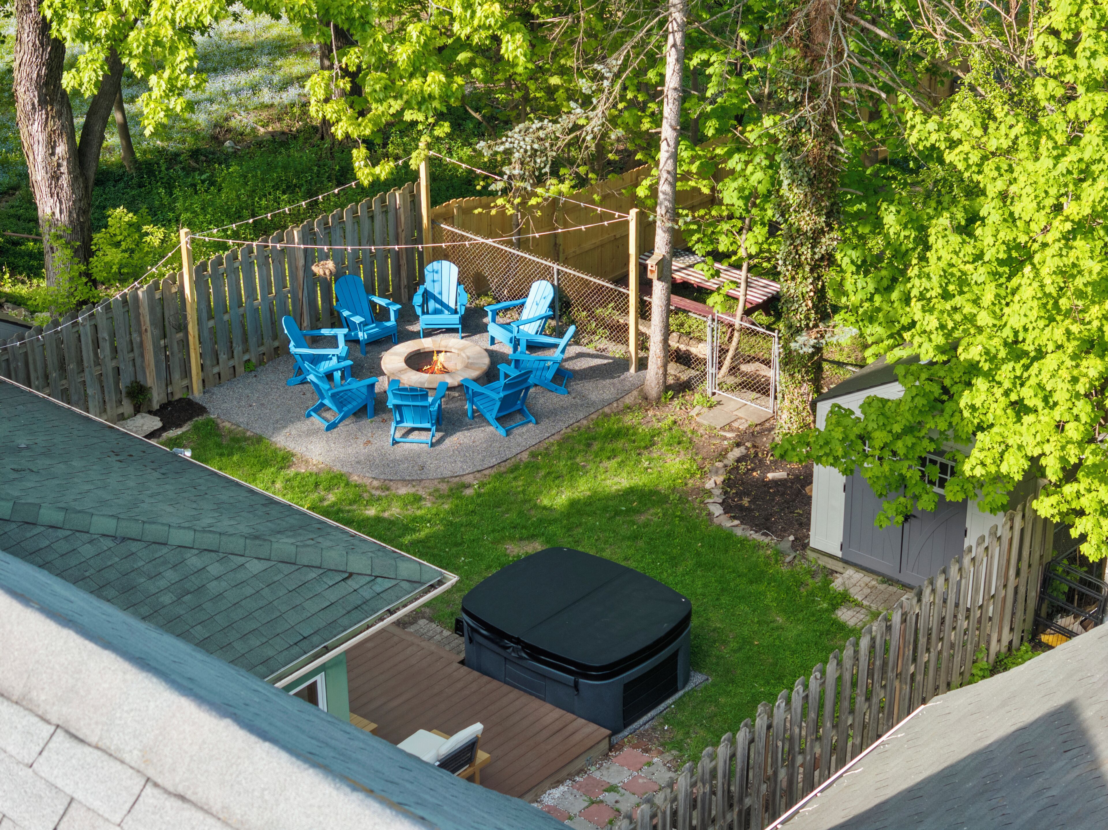 Ein Garten mit Feuerstelle, Sitzgelegenheiten im Freien und einem Whirlpool.