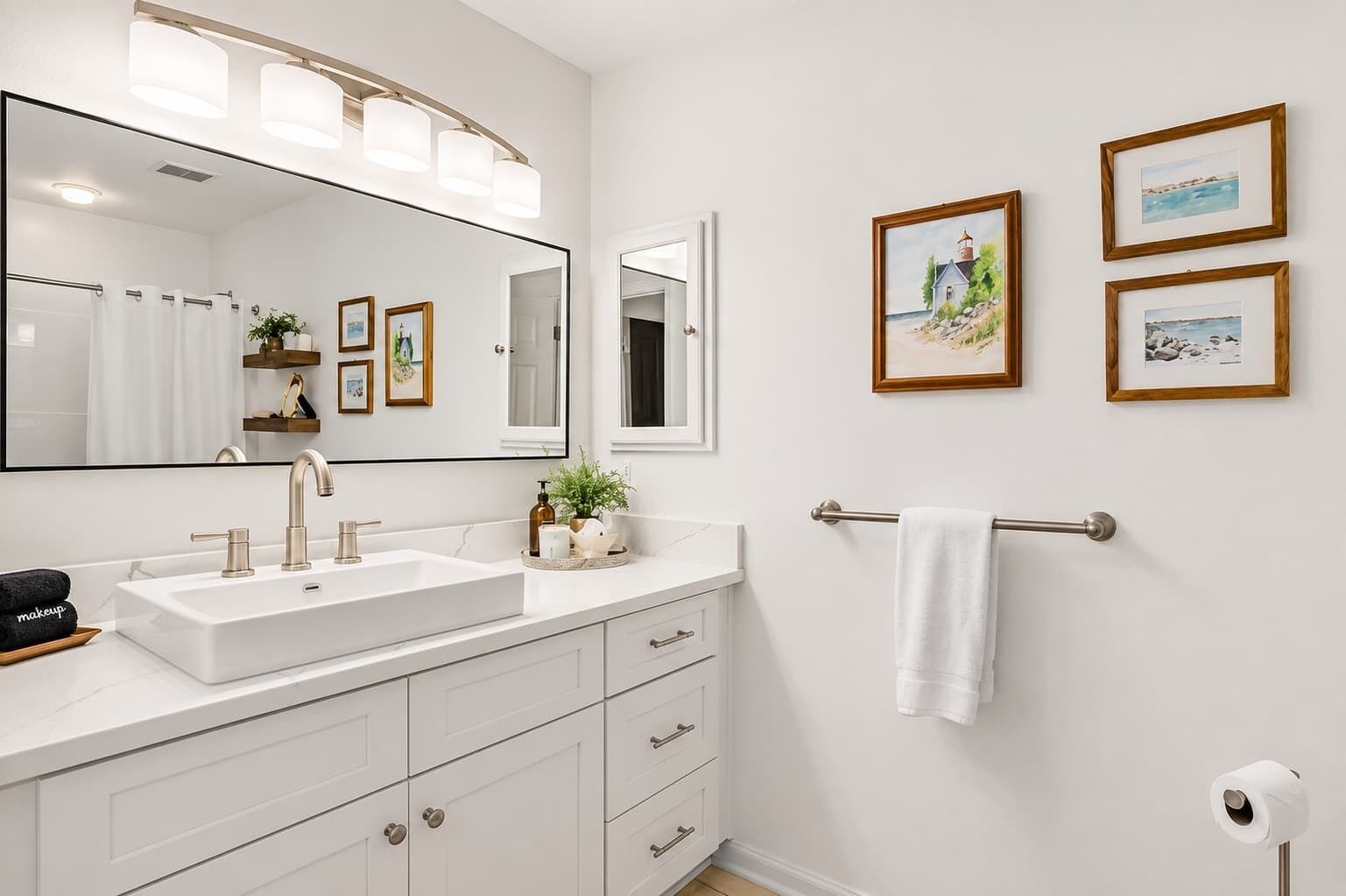 Ein modernes Badezimmer mit einem großen Spiegel, zwei Waschbecken und einem Handtuchhalter.