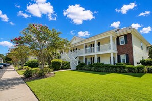 A two-story residential building with a front porch and a staircase leading to the upper level. - Coastal Chic Golf Retreat Fairways 18F (Myrtle Beach)