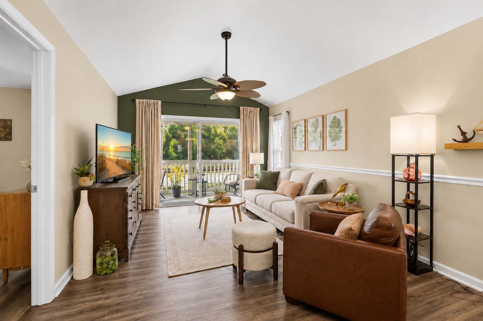 A living room with a sofa, armchair, coffee table, and a television on a stand.
