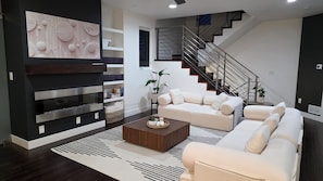 Una sala de estar moderna con sofá, mesa de centro y decoración en la pared.