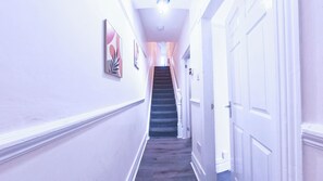 Ein Flur mit einer Treppe, die zu einer Tür führt.