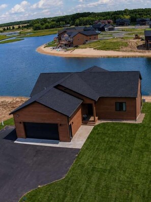 Una casa moderna con garage, in posizione tranquilla vicino all'acqua e circondata dal verde.