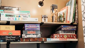 Una estantería con varios juegos de mesa y libros.