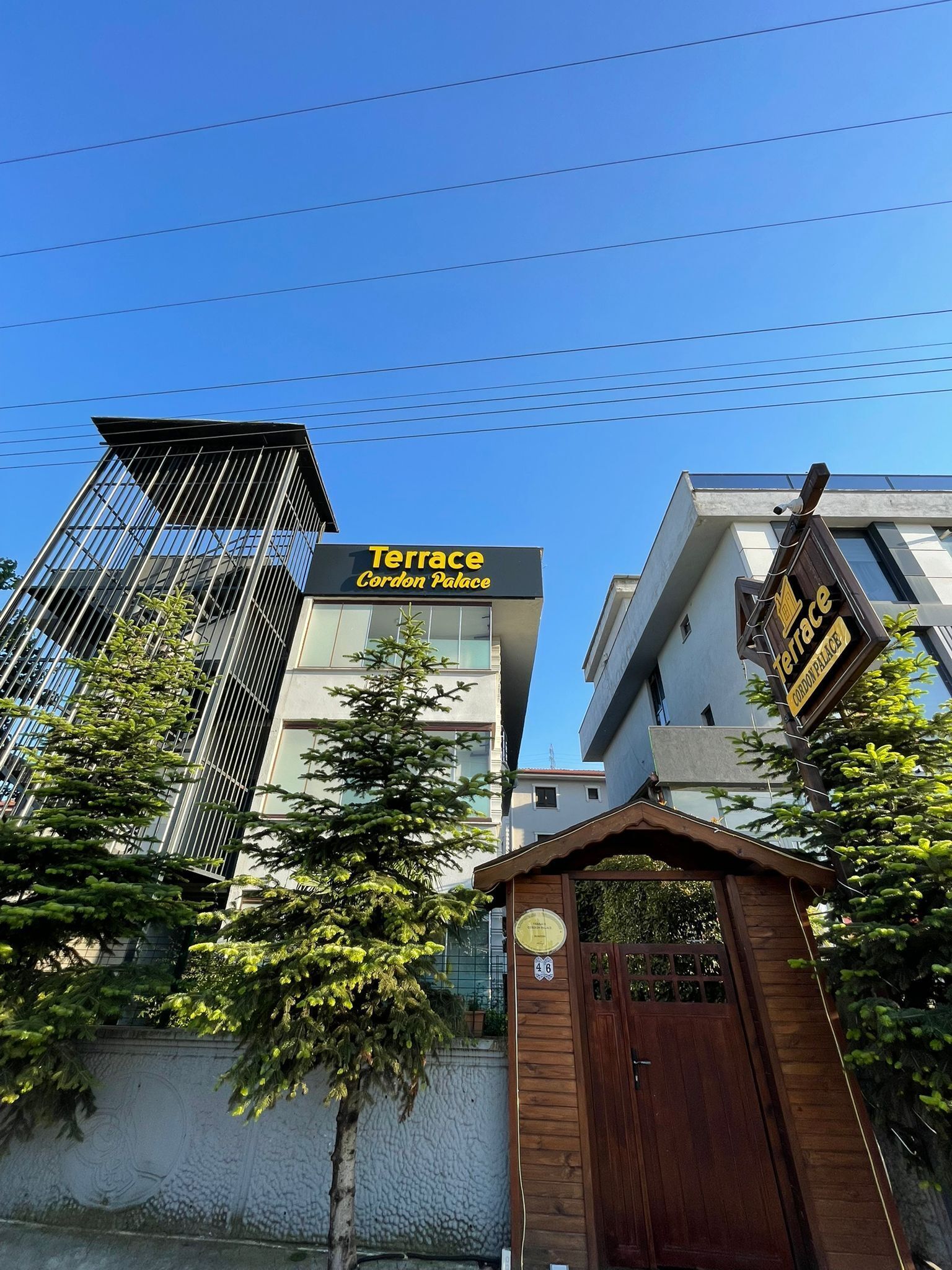 A modern building with a sign for 'Terrace Cordon Palace' and a gated entrance.