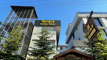 A modern building with a sign for 'Terrace Cordon Palace' and a gated entrance.