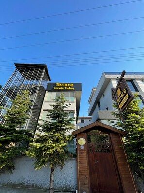 Un edificio moderno con un letrero que dice 'Terrace Cordon Palace' y una entrada protegida por una reja.
