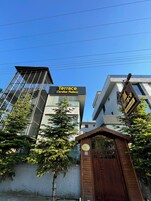 Un edificio moderno con un letrero que dice 'Terrace Cordon Palace' y una entrada protegida por una reja.