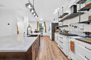 A modern kitchen with a central island, stainless steel appliances, and a view to the dining area.