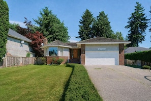 A single-story house with a garage, a well-maintained lawn, and a driveway.