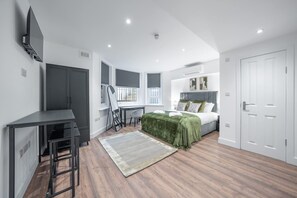 Ein modernes Schlafzimmer mit Bett, Schreibtisch und Kleiderschrank.