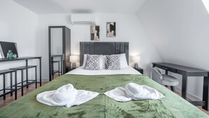 A modern hotel room with a large bed, two bedside tables, a desk, and a chair. - Top Floor Studio With View in Knightsbridge (London)