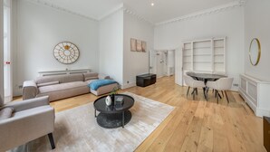Uma sala de estar espaçosa com sofá, mesa de centro e área de jantar com cadeiras e mesa.