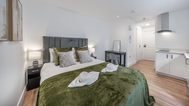 A modern hotel room with a large bed, bedside tables, a desk, and a kitchenette. - Superior Ground Floor Studio in Knightsbridge (London)