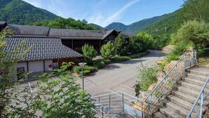 Un bâtiment doté d’un toit à pente traditionnelle, d’une aire de stationnement et d’un escalier menant à un niveau supérieur.
