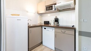 A compact kitchen with a microwave, toaster, coffee maker, and dishwasher.