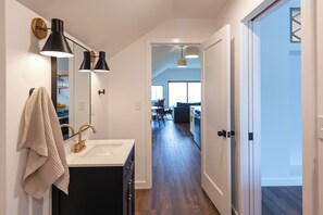 Eine moderne Küche mit einem weißen Spülbecken, schwarzen Schränken und einem Handtuch an der Wand.